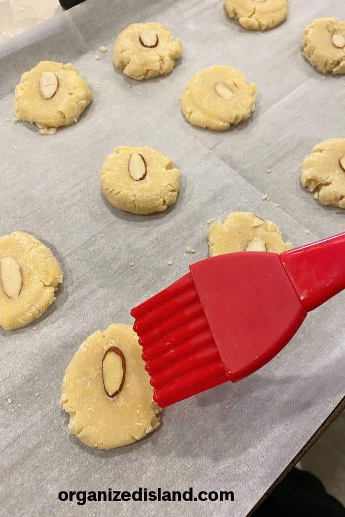 Brusning egg wash on almond cookies