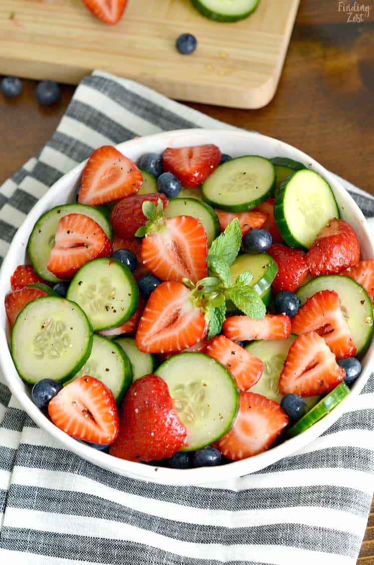 This is a picture of a fresh berry and cucumber salad with mint, strawberries and blueberries.