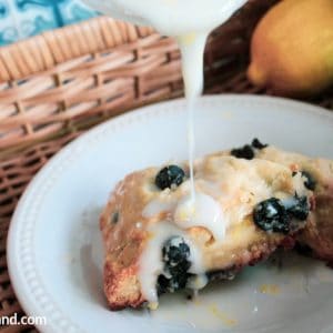 Easy Blueberry Scones on plate with icing dripping on them.