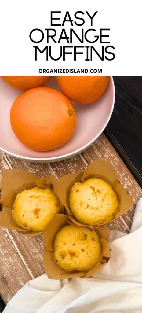 Orange Muffins on tray next to bowl of oranges.