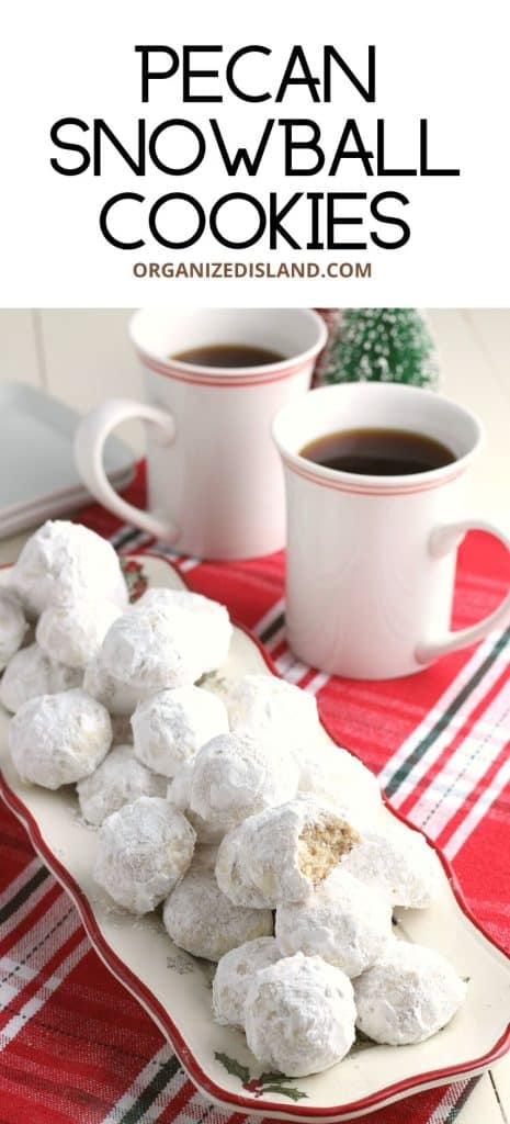 Pecam snowball cookies stacked next to coffee mugs.