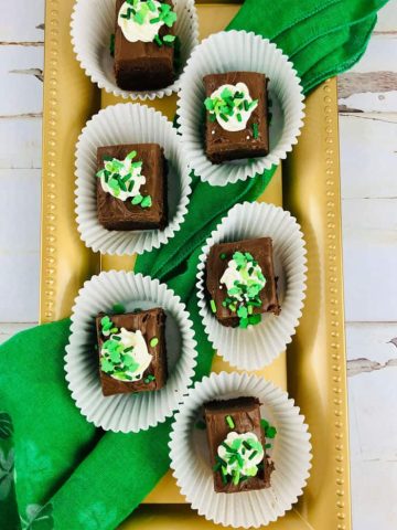 green frosted brownies on tray.
