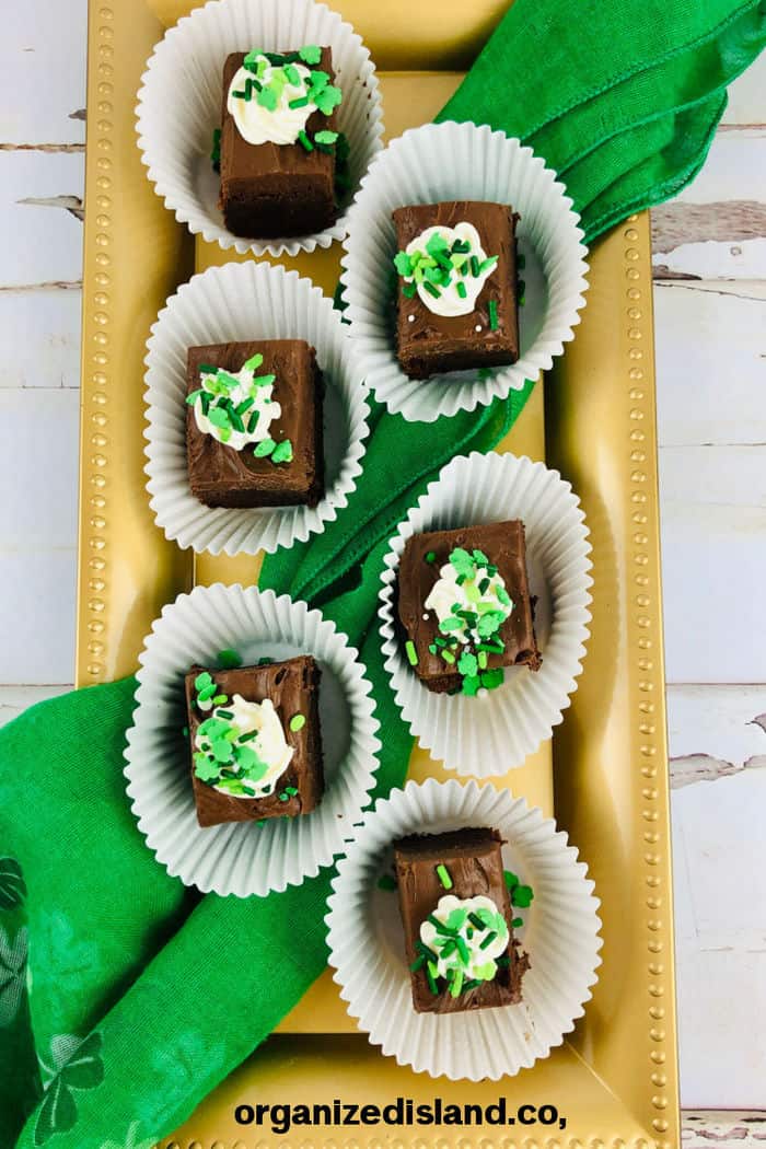 green frosted brownies on tray.
