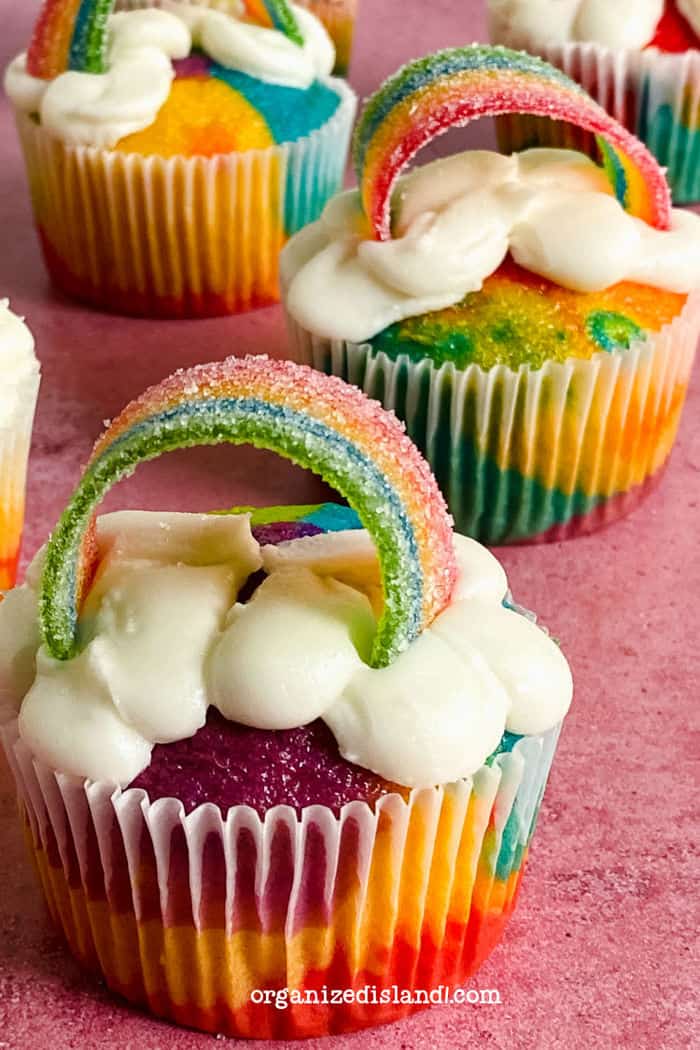 Easy Rainbow Cupcakes on pink table.