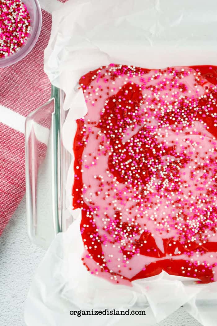 Pink Fudge in baking dish with sprinkles.