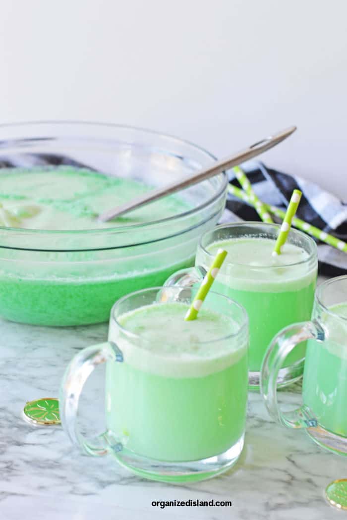 Lime Sherbet Punch in cups with punch bowl.