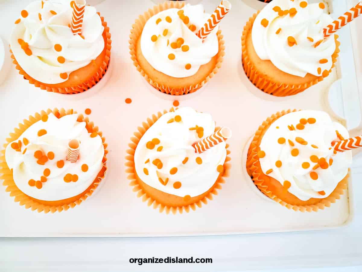 Creamsicle cupcakes in tray.