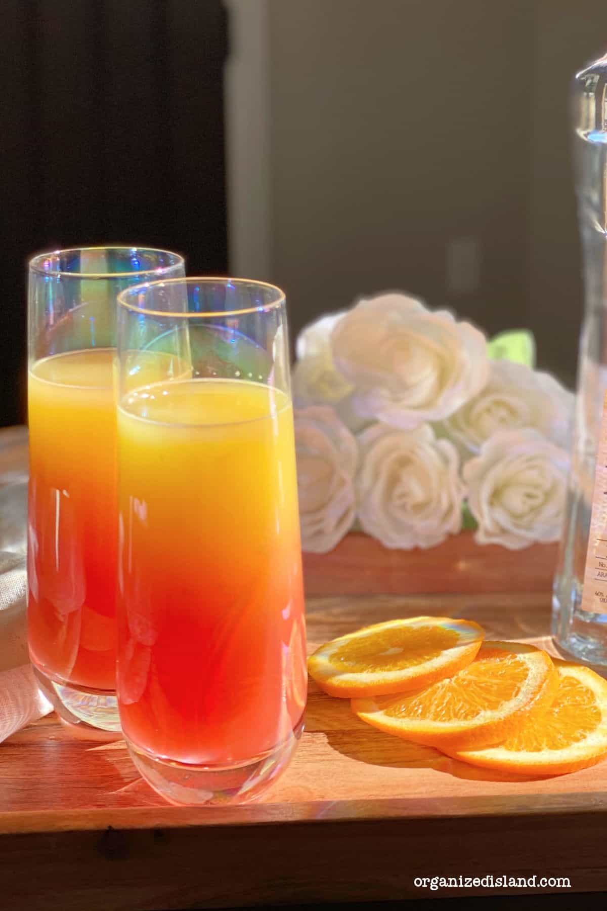 Tequila Sunrise Mimosas with orange slices.