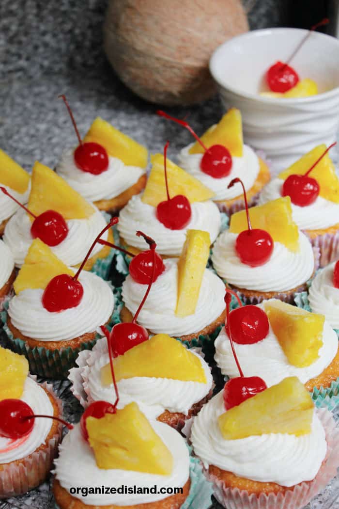 Pina colada Cupcakes with cherries and pineapple wedges.