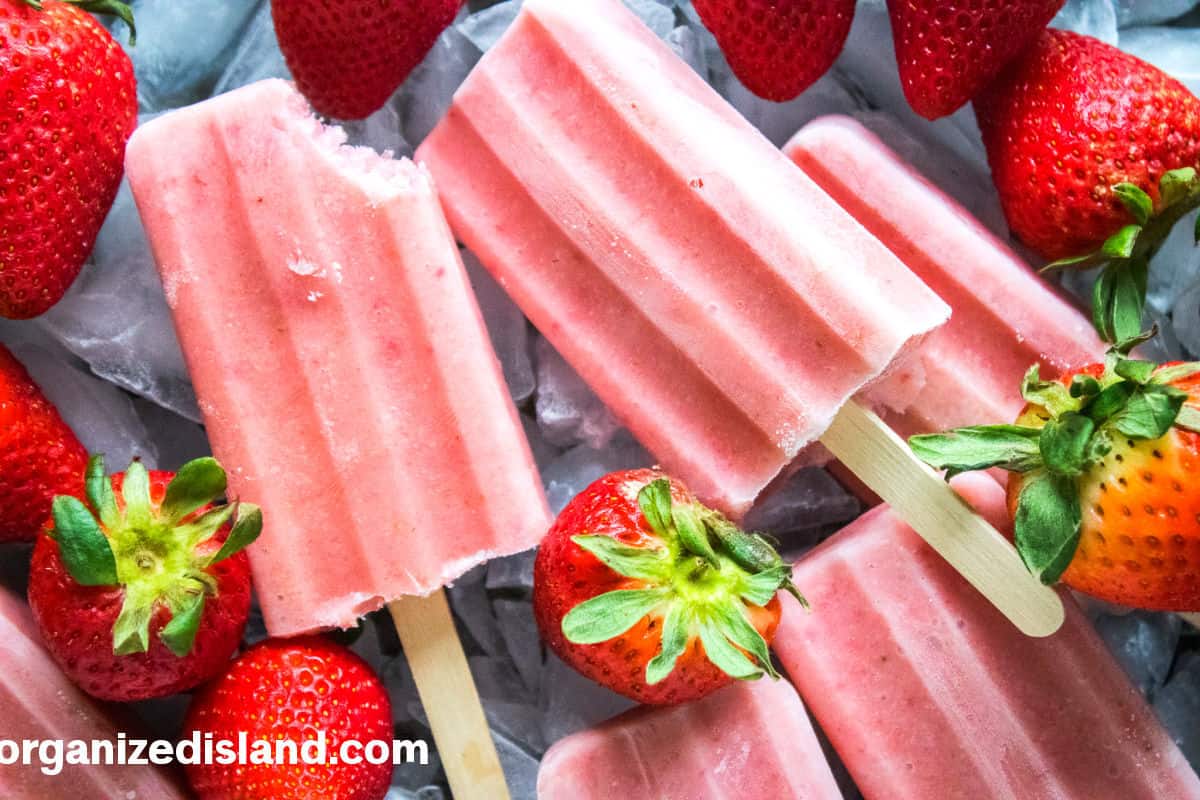 Strawberry Banana Popsicles with bite out of one.