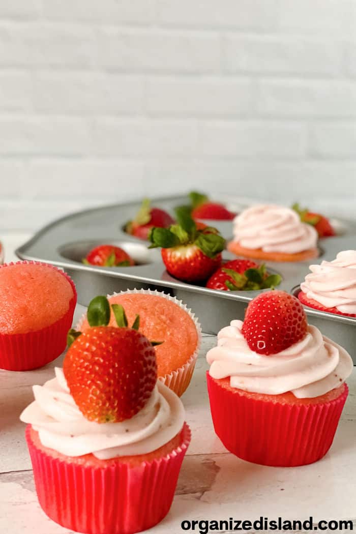 strawberry cupcakes in baking pan with whole strawberries
