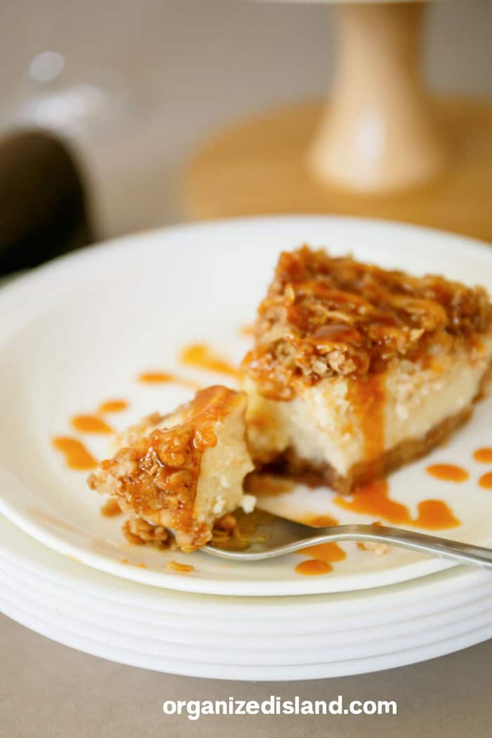 Apple Crumble Cheesecake on plate with caramel sauce.