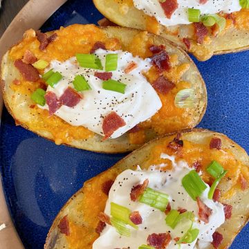 Stuffed Potato Skins with cheese, bacon and onions on plate