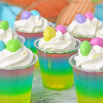 Easter Jello Shots with three layers topped with whipped cream.