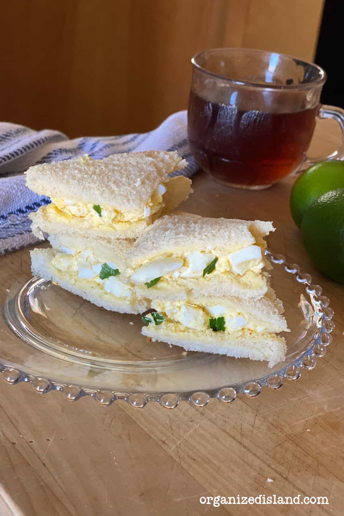 Egg Salad Tea Sandwiches stacked on plate.