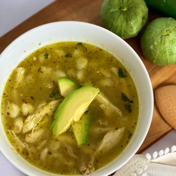Best chicken Pozole in soup bowl topped with avocadoe slices.