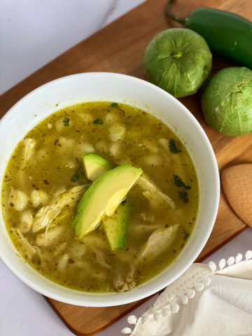 Best chicken Pozole in soup bowl topped with avocadoe slices.