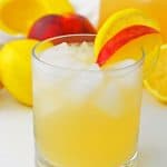 Peach Lemonade in glass with peach slice.