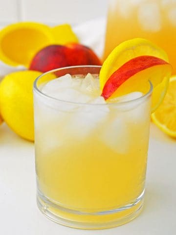 Peach Lemonade in glass with peach slice.