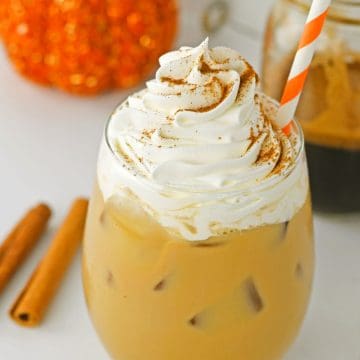 Iced Pumpkin Spice Latte in glass with whipped cream.