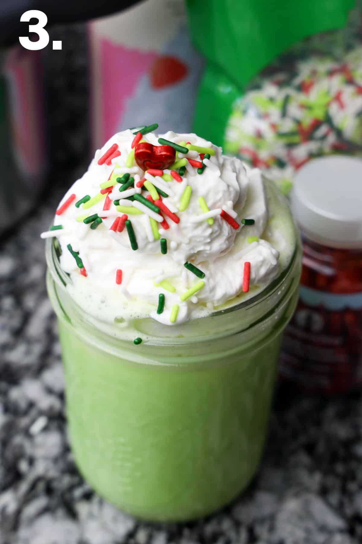 How to make Grinch Hot Chocolate - adding sprinkles and red heart. cloring.
