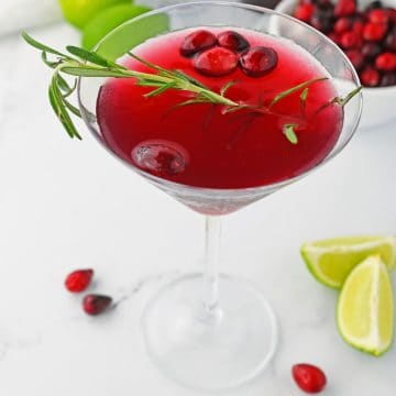 Mistletoe Martini in glass with cranberries.