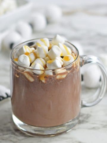 Cream Caramel Hot Chocolate with marshmallows and caramel sauce incup.