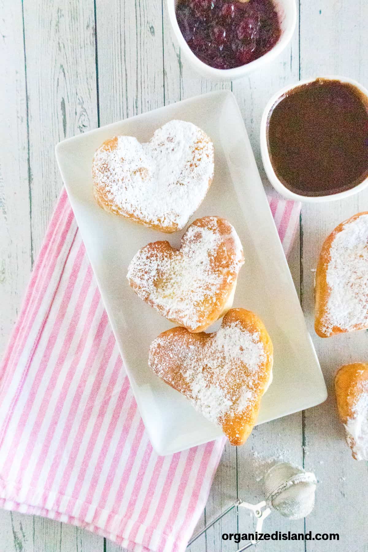 Heart Shaped Beignets on plate with chocolate sauce.