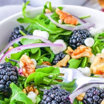 Arugula Salad with Goat Chees and berries in bowl.
