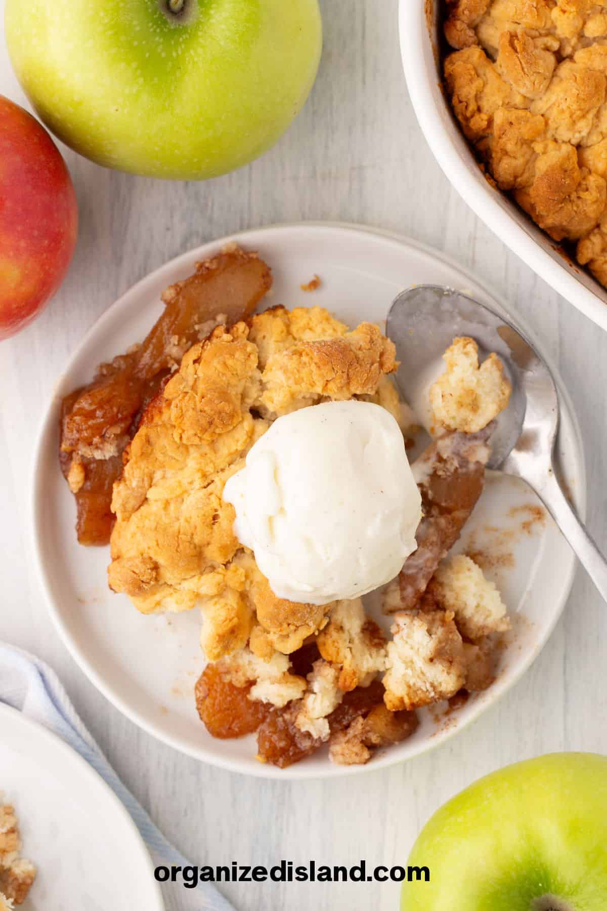 Bisquick Apple Cobbler on plate next to cobbler in dish.