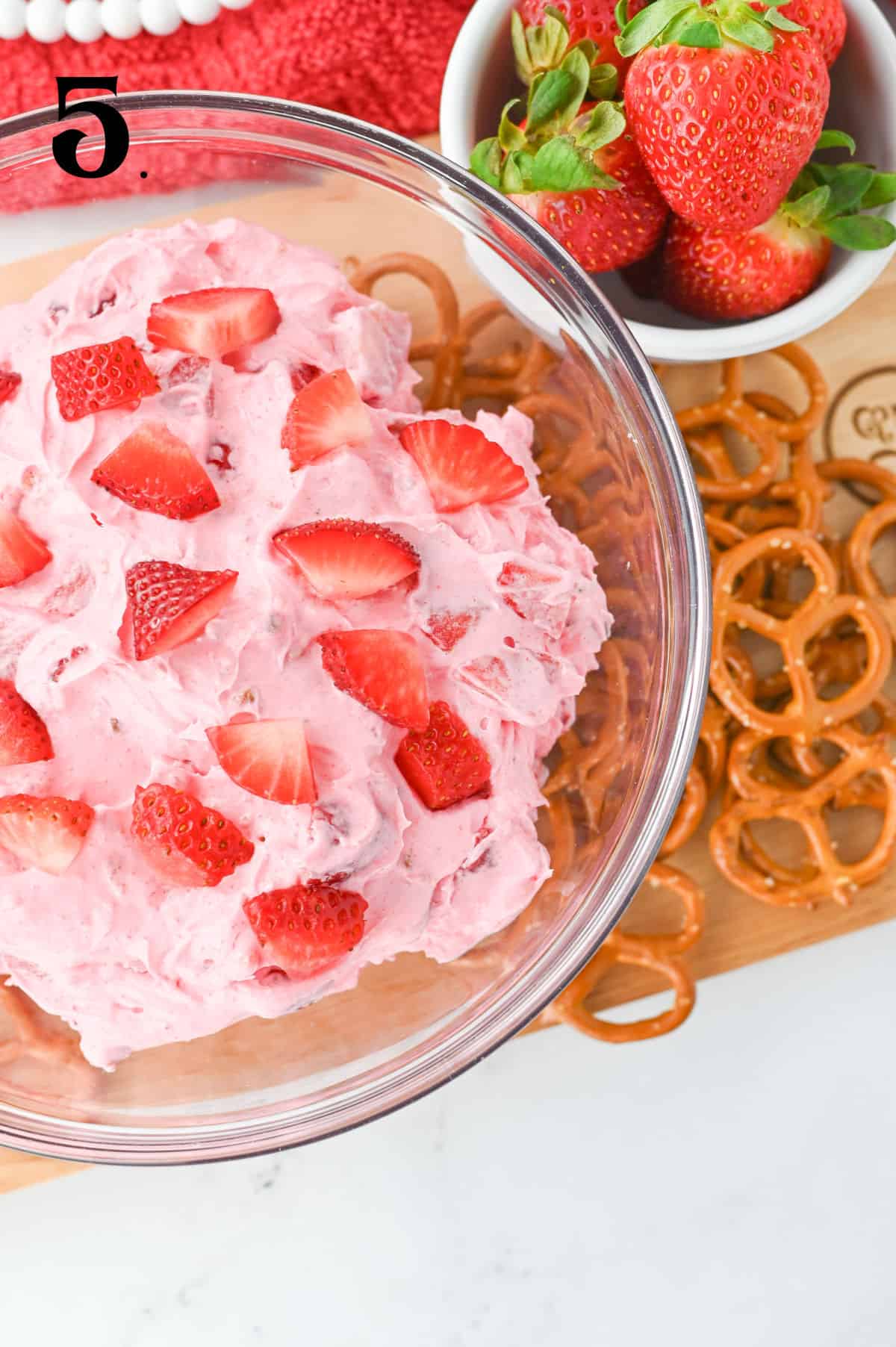 How to make Strawberry Pretzel Dip step 5 with fresh strawberries in bowl.