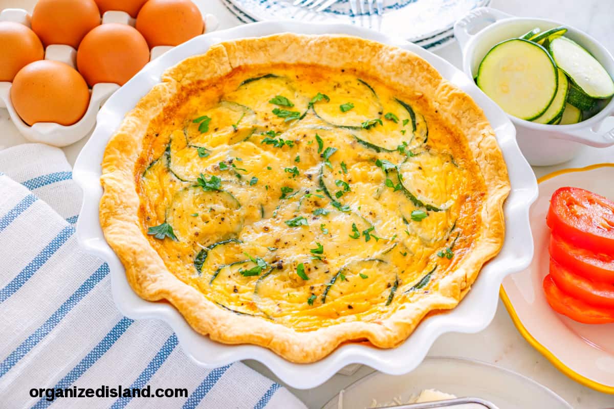 Best Zucchini Quiche baked in a white pie pan.