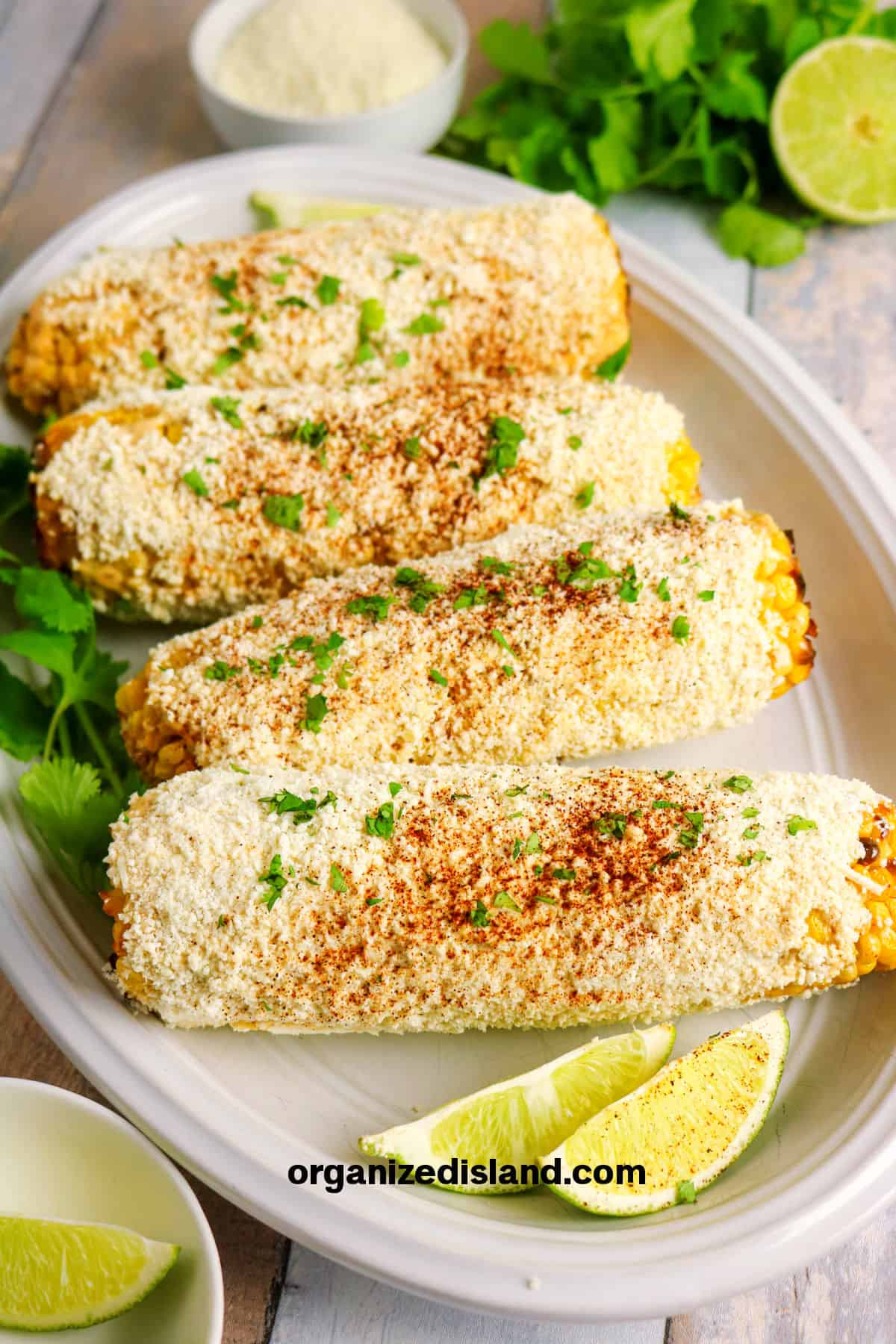 Delicious cornbread with lime wedges and cilantro on a white platter.