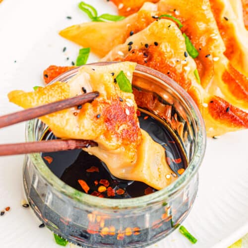 Easy Potstickers dipped in sauce on white plate