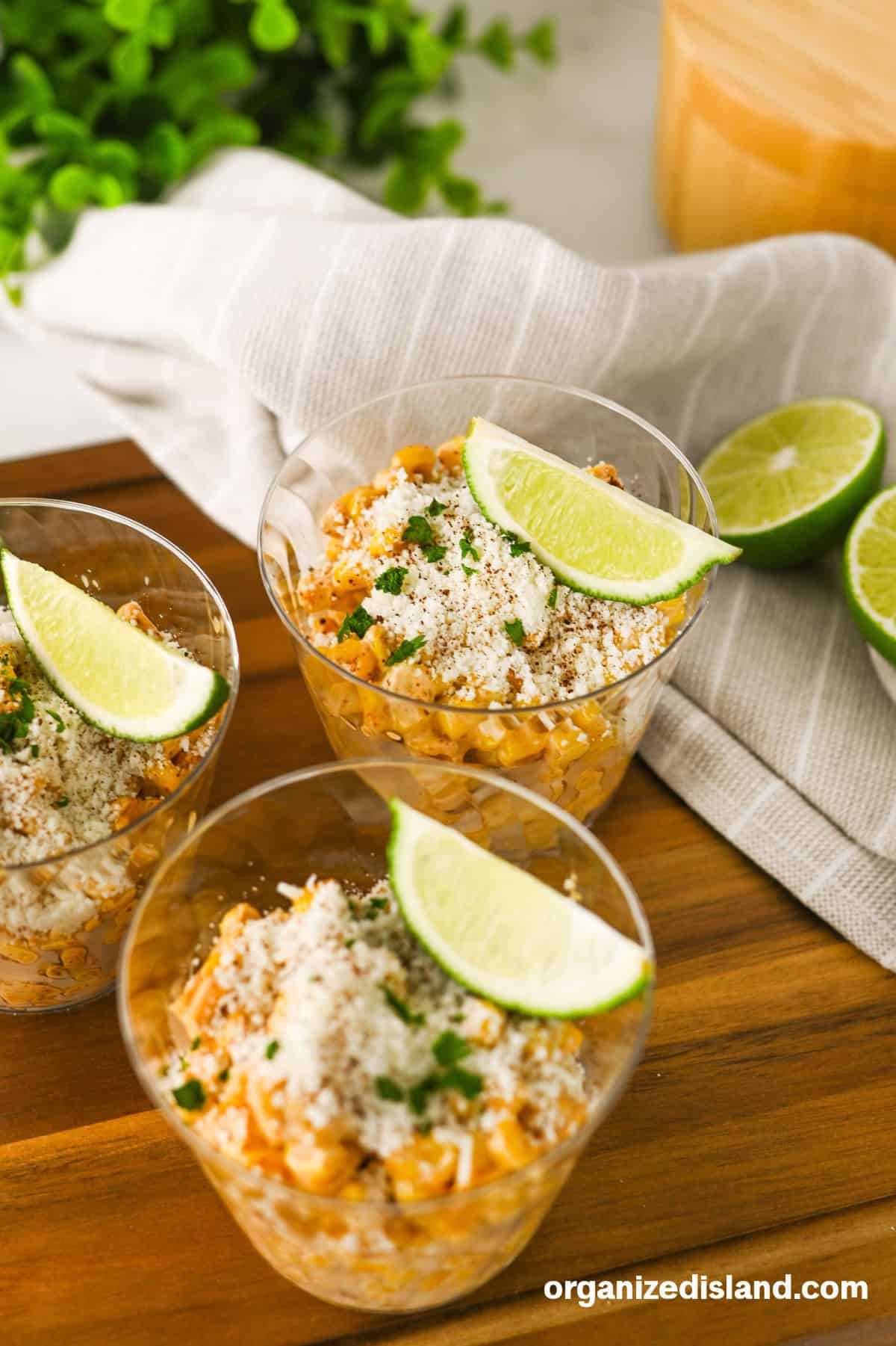Elotes Cups with cheese and limes on top.
