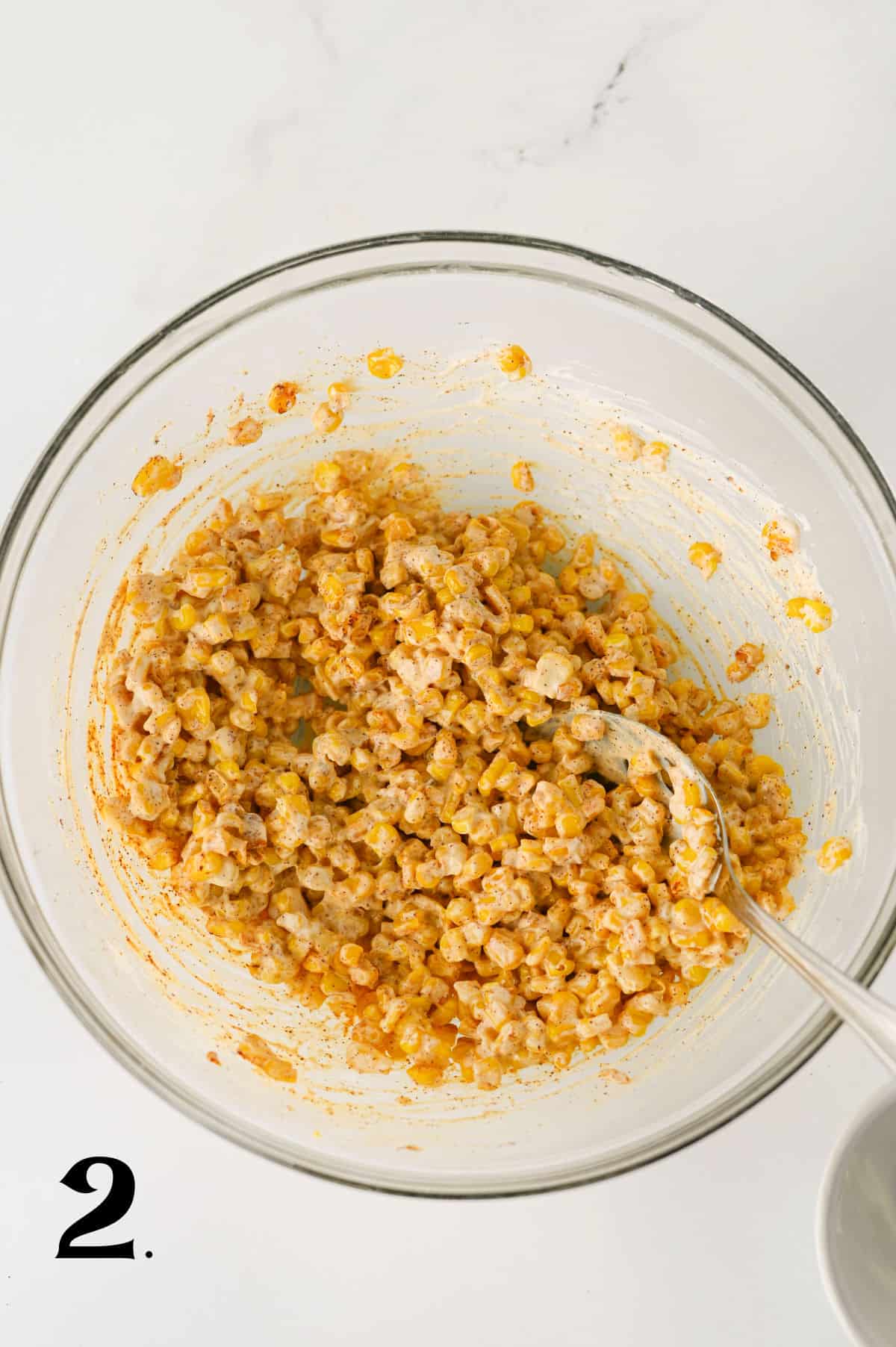 _How To Make Elotes Cups Step 2 - Mixing corn with seasonings in bowl.