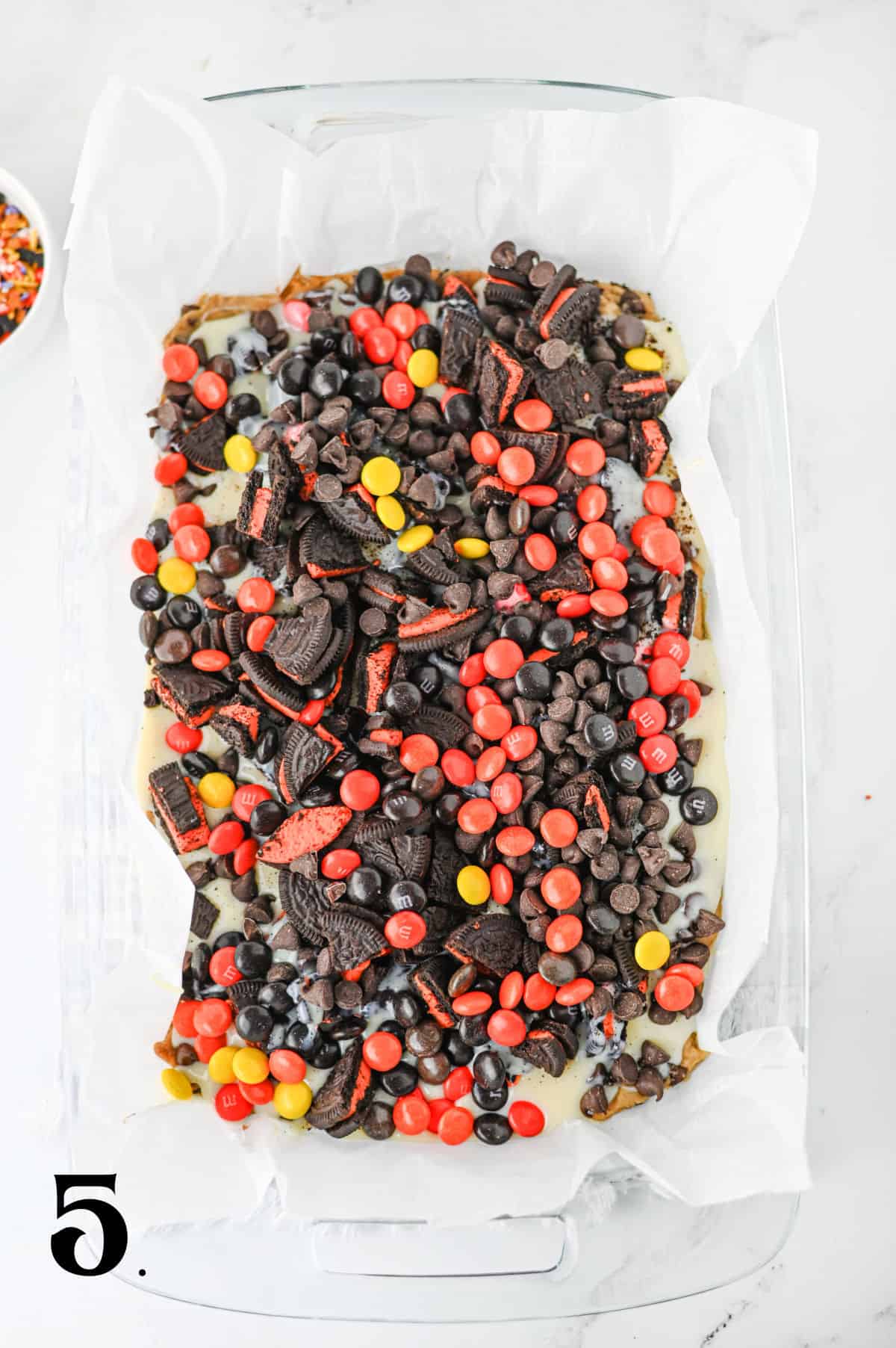 How to Make Halloween Cookie Bars Step 5 - pressing leftover Halloween Candy into dough.