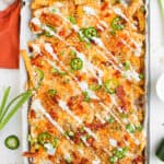 Loaded Fries with sour cream and cheese on sheet pan.
