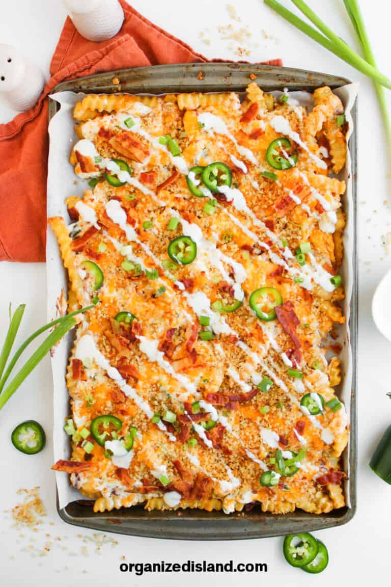 Loaded Fries with sour cream and cheese on sheet pan.