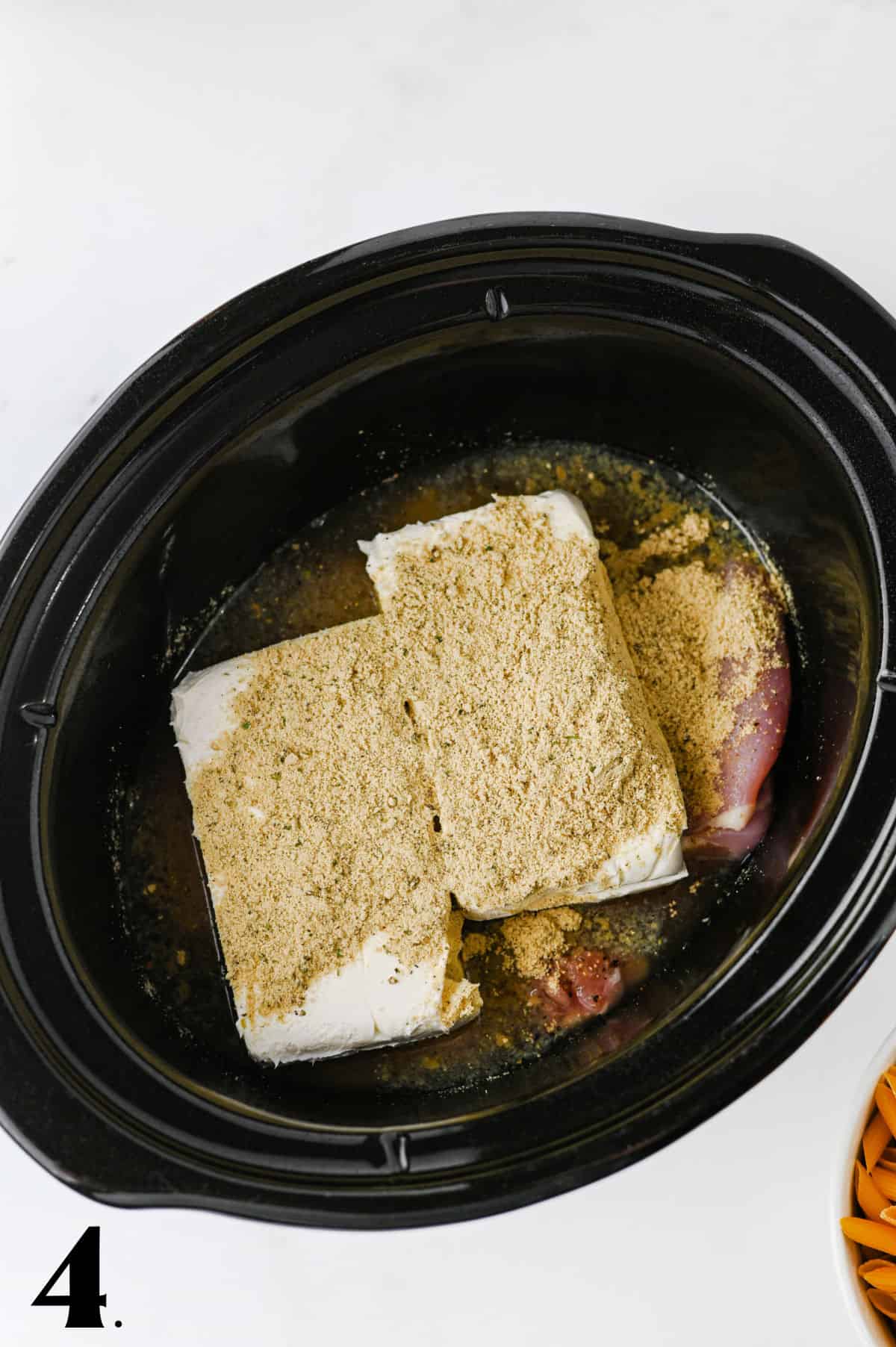 How to Make Crockpot Crack Chicken Pasta Step 4 adding cream cheese blocks and ranch seasoning.