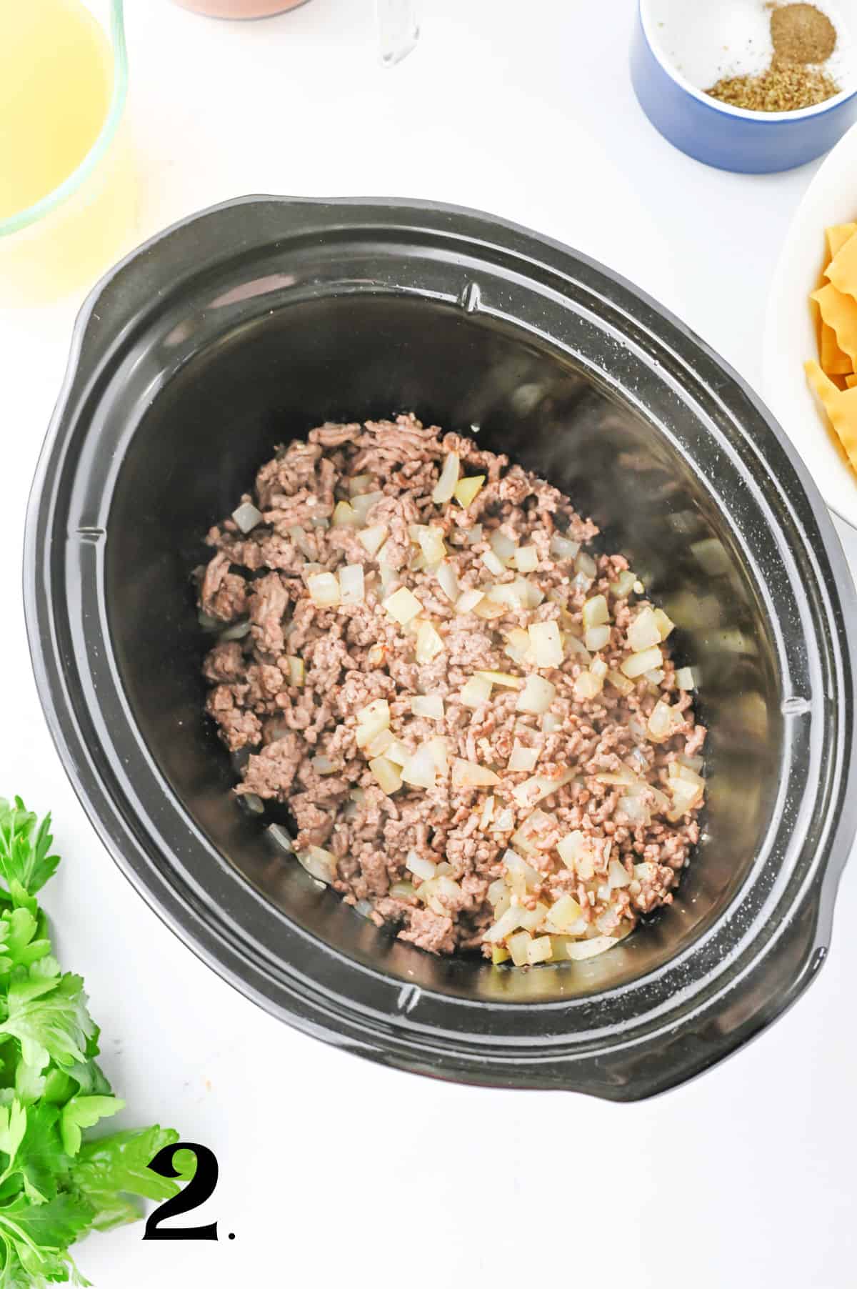 w to Make Crockpot Lasagna Soup Step 2 - adding cooked ground beef and nions to slow cooker.