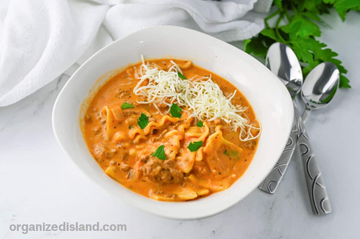 How to Make Slow Cooker Lasagna Soup topped with cheese.