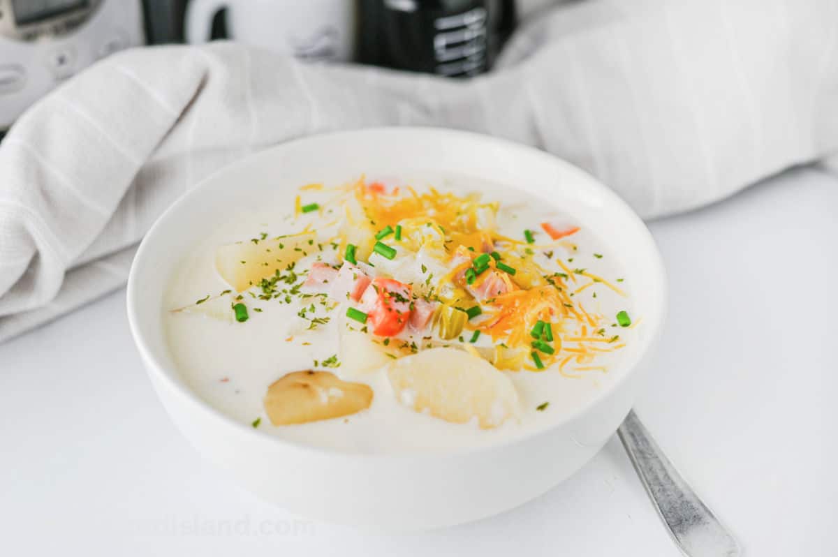 Best Slow Cooker Ham and Potato Soup in bowl topped with green onions.