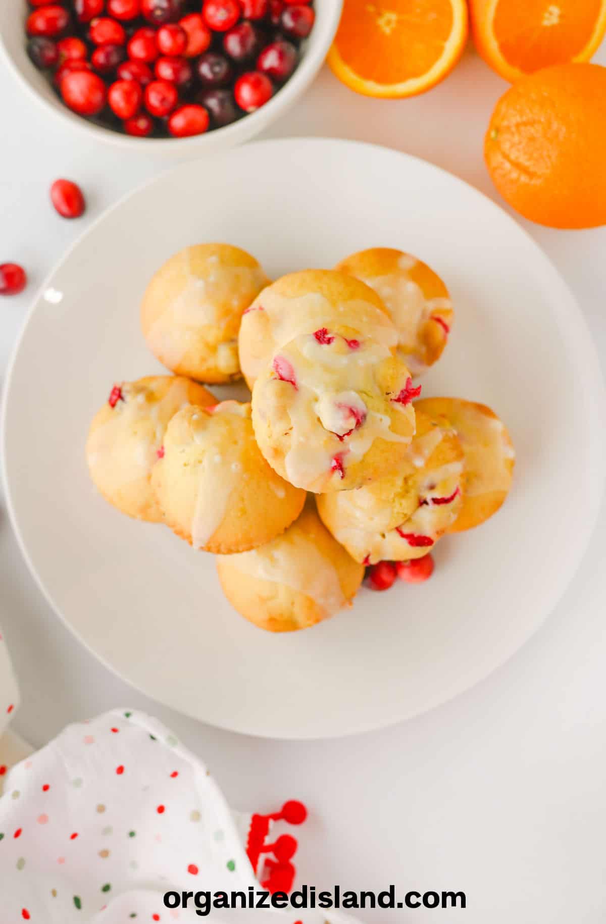 Easy Cranberry Orange Muffins on plate with fresh cranberries.