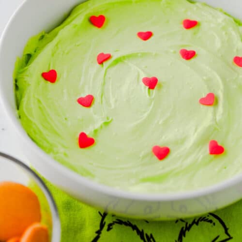 Grinch Dip - green cool whip dip in bowl with candied hearts on top.