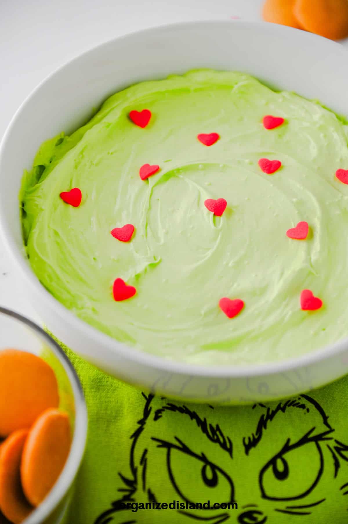 Grinch Dip - green cool whip dip in bowl with candied hearts on top.