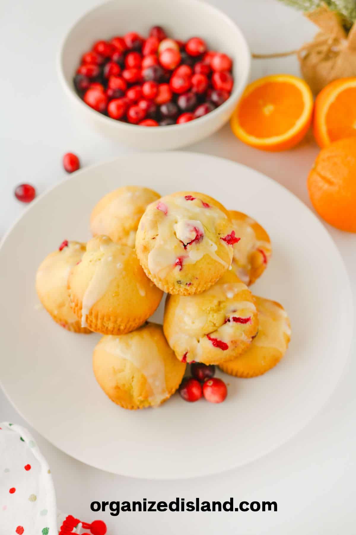 Soft Cranberry Orange Muffins with glaze on plate.