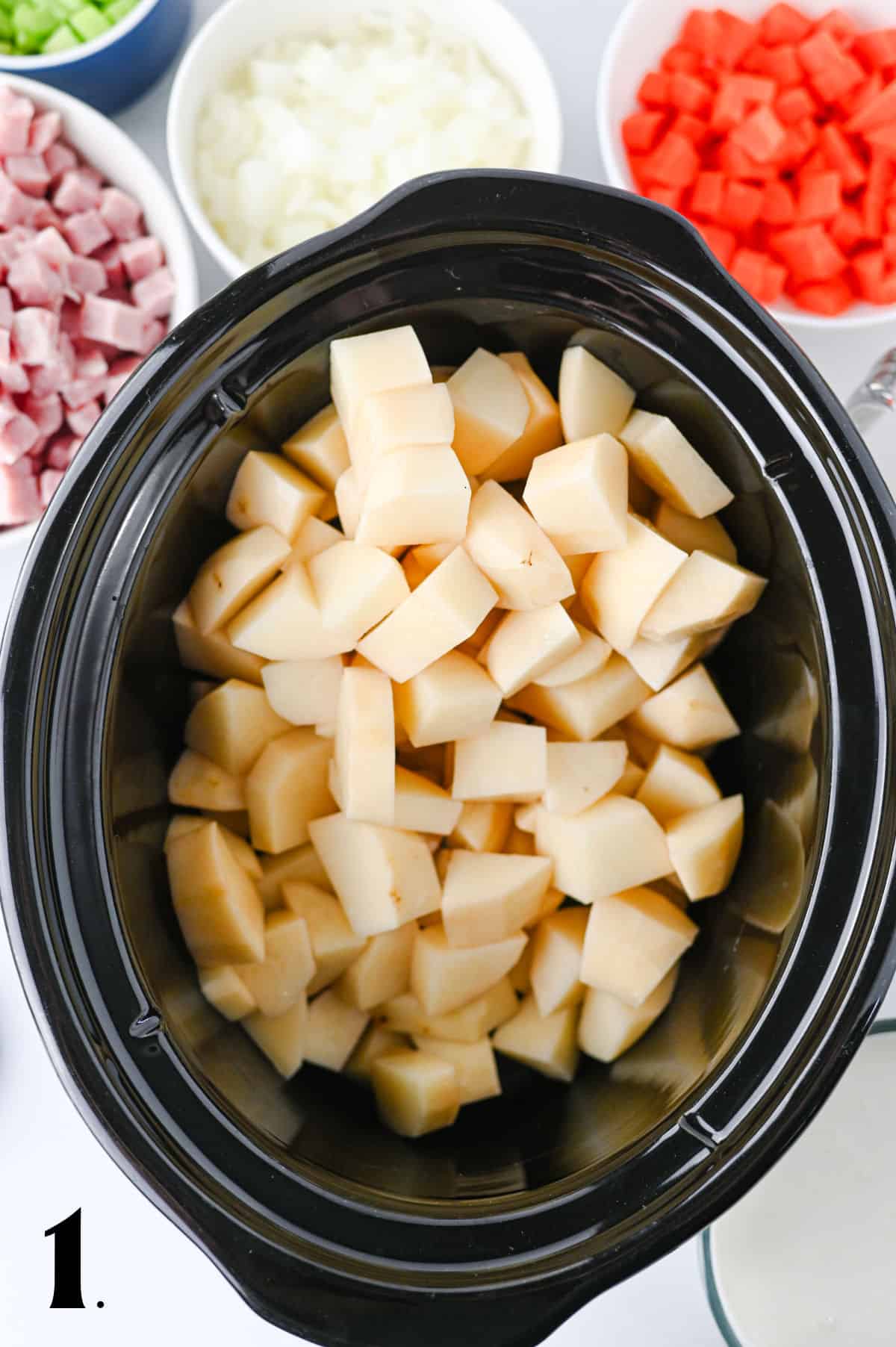 How to Make Slow Cooker Ham and Potato Soup Step 1 - adding potatoes to slow cooker.