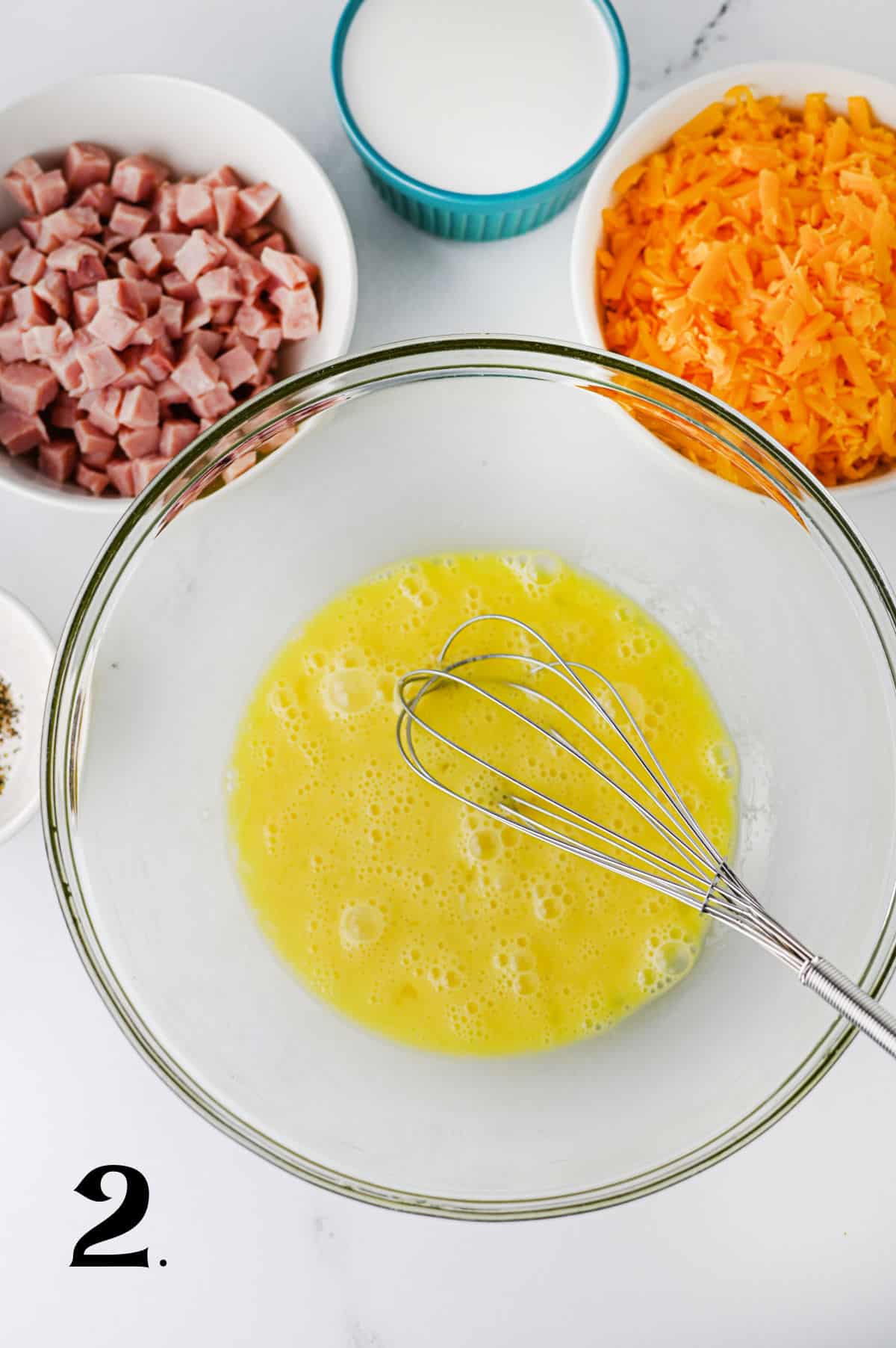 How to make a Ham and Cheese Quiche Step 2 - adding eggs to bowl.