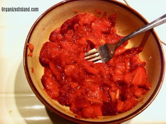 Crushing strawberries for strawberry shortcake.